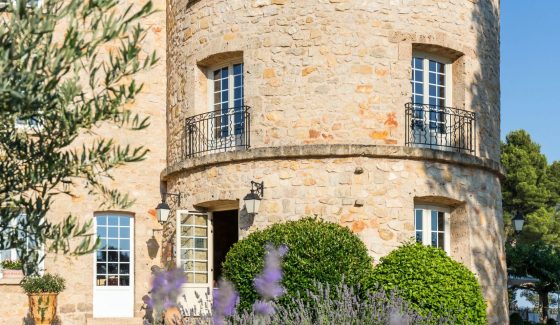 Close-up view with lavender in the foreground and a tower of the Bastide de Tourtour in the background